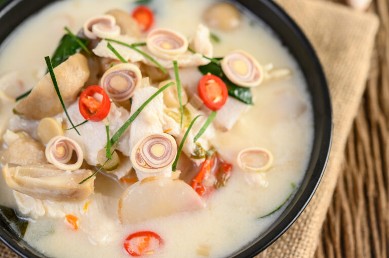 Tom Kha Kai in a pan frying with kaffir lime leaves, lemongrass,